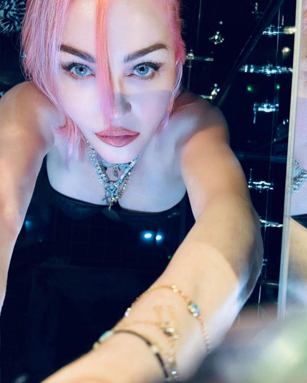 Madonna w kominiarce rzuca się w konwulsjach po łóżku. W ręce trzyma pejcz. "Ocknij się kobieto"