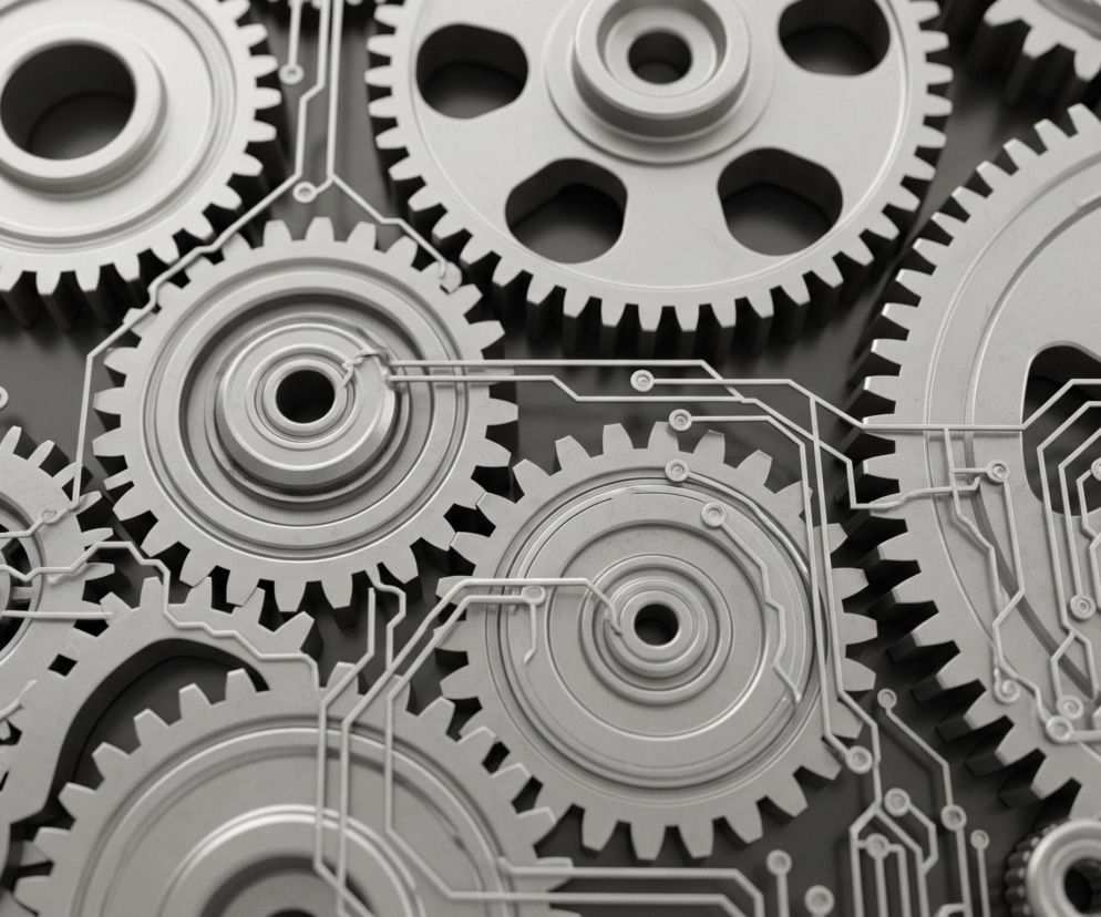 Większość kadru wypełniają metalowe koła zębate w różnych rozmiarach, o jasnoszarym kolorze. Pomiędzy nimi i na ich powierzchniach biegną jasne, wąskie linie układu elektronicznego, przypominające ścieżki na płytce drukowanej, z małymi okrągłymi elementami na końcach lub rozwidleniach. Tło stanowi ciemnoszara powierzchnia, na której rzucane są cienie przez wypukłe elementy kół zębatych i obwody elektroniczne. Całość ma mechaniczny, a jednocześnie futurystyczny wygląd.