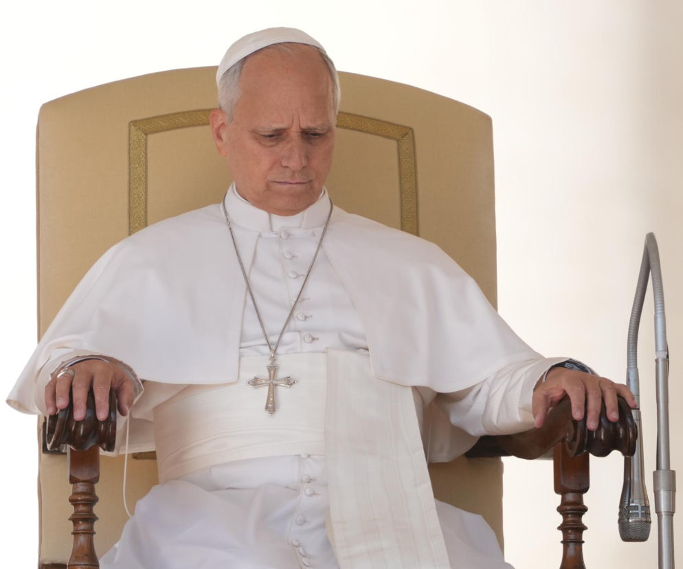 Papież Leon XIV w białej sutannie siedzi na tronie z zamyśloną miną. O dyplomacji Watykanu przeczytasz na SE Polityka.