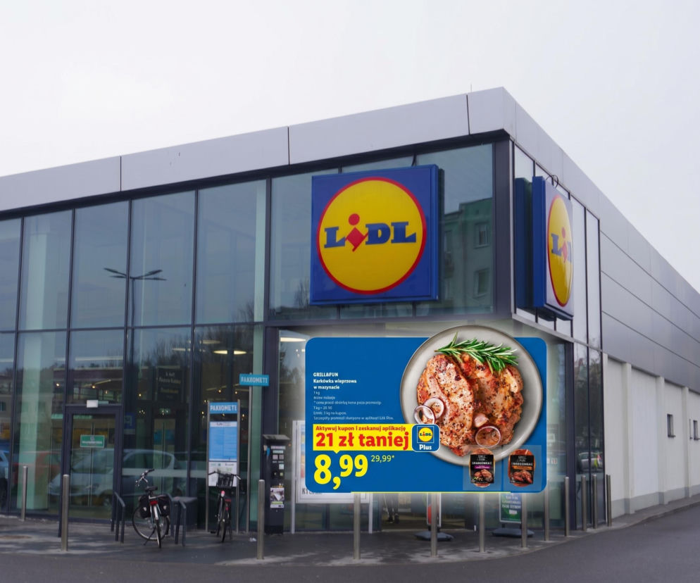 Zewnętrzny widok na sklep Lidl z dużą reklamą promocyjną na karkówkę wieprzową Grill&Fun za 8,99 zł/kg, widoczną na tle przeszklonej fasady. Oferta karkówki i inne grillowe hity Lidla na majówkę dostępne są do przeczytania na portalu Super Biznes.