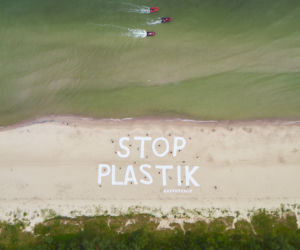 Wielki napis Stop plastik na plaży w Kołobrzegu