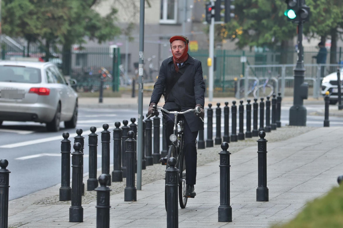 Maciej Gdula na rowerze. Chroni uszy przed chłodem