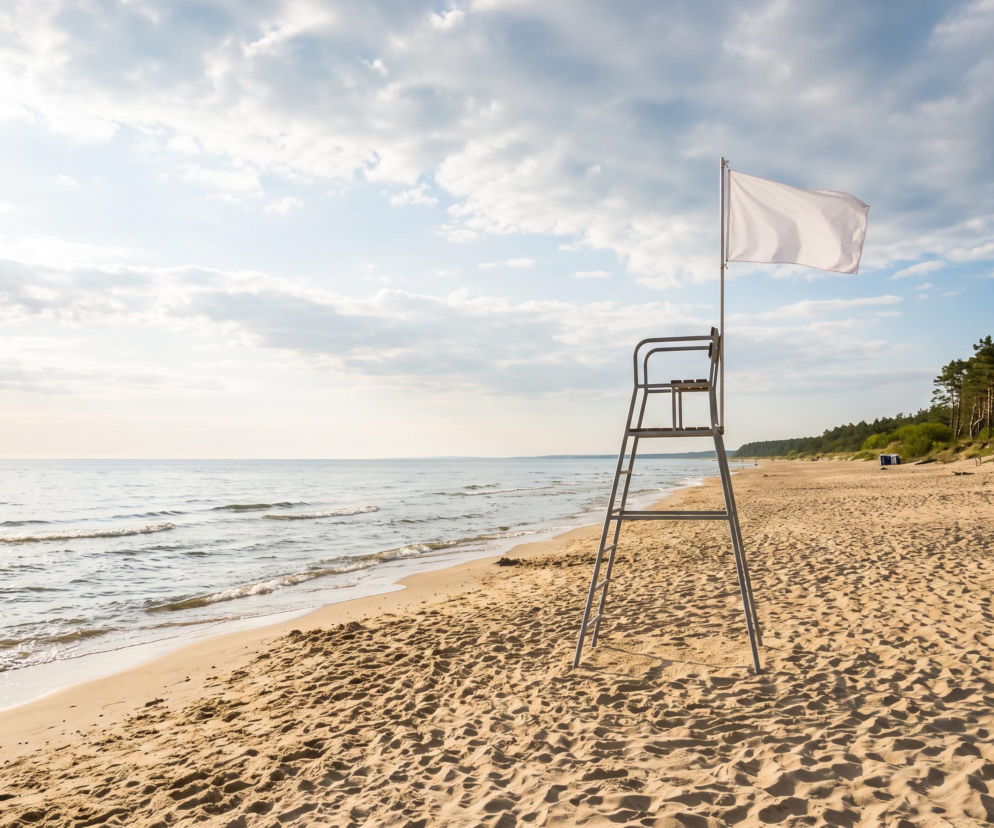 Biała flaga na wieży ratowniczej na pustej plaży w Stegnie. O warunkach kąpieli przeczytasz na Eska Trójmiasto.