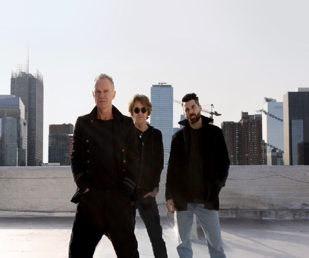 Sting, Dominic Miller i Chris Maas stoją na dachu budynku. O trasie STING 3.0 w Polsce przeczytasz na EskaRock.