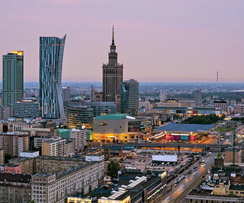 Panorama Warszawy z wieżowcami i Pałacem Kultury o zmierzchu. O pracy migrantów w Polsce przeczytasz na Mediateka.