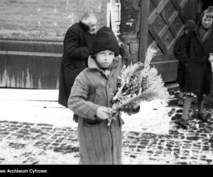 Chłopiec sprzedający palmy wielkanocne przed kościołem w Krakowie (1931)