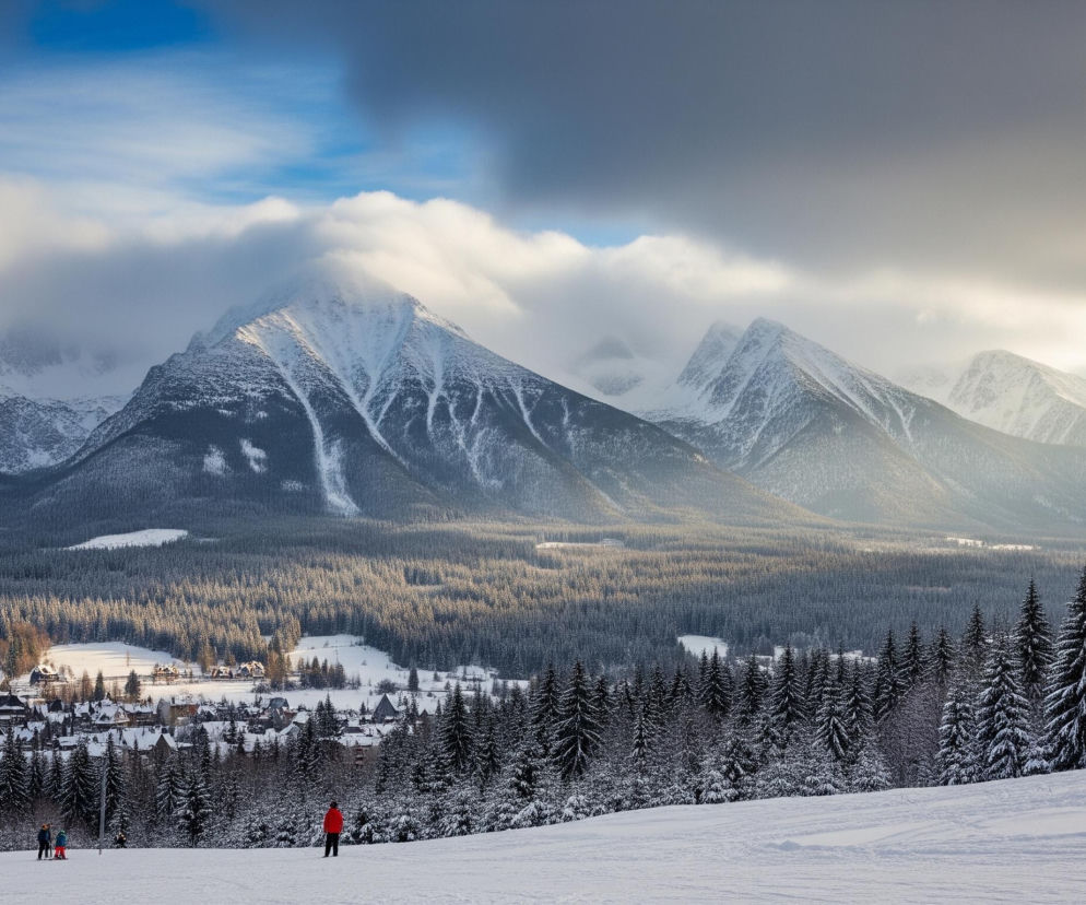 Rozległy, zimowy krajobraz ukazuje pokryte śniegiem góry w tle, z widocznymi skalistymi szczytami częściowo zakrytymi chmurami. Poniżej rozciąga się gęsty las iglasty, również przysypany śniegiem, tworząc ciemnozielone pasmo na środku obrazu. W dolinie, pomiędzy lasem a stokiem narciarskim, leży wioska z licznymi domami o spadzistych, zasypanych śniegiem dachach, oświetlonymi ciepłym światłem słonecznym. Na pierwszym planie znajduje się szeroki, ośnieżony stok narciarski, na którym widoczne są ślady po nartach oraz kilka postaci ubranych w kolorowe kombinezony, stojących lub jeżdżących na nartach. Niebo nad górami jest mieszanką błękitu i szarych chmur, z promieniami słońca przebijającymi się po prawej stronie.