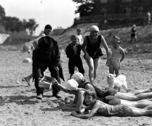 Plażowicze podczas wypoczynku. Widoczny sprzedawca obwarzanków, Kraków wrzesień 1929. Plaża nad Wisłą.