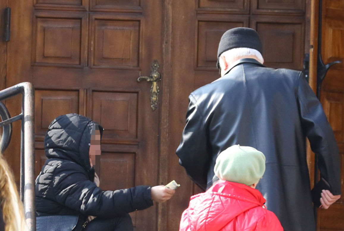 Lech Wałęsa daje pieniądze pod kościołem