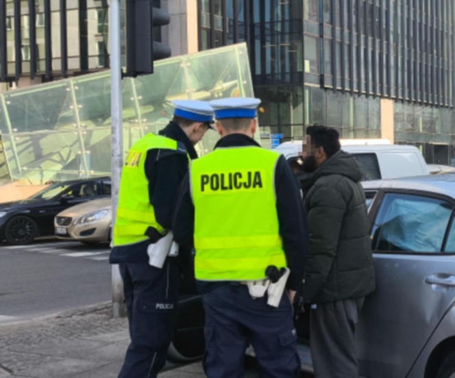 Kierujący autem, które dachowało rozmawia z policjantami