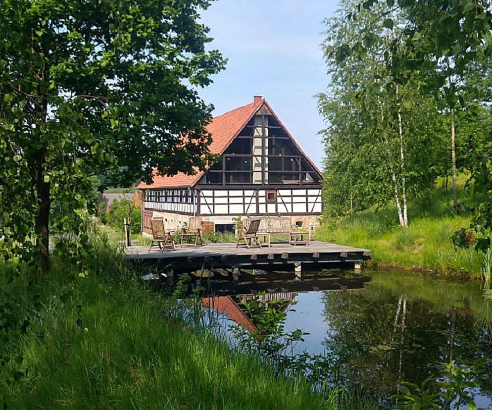 Sudecka zagroda z szachulcowym piętrem i czerwonym dachem nad stawem. O metamorfozie domu przeczytasz na Muratordom.