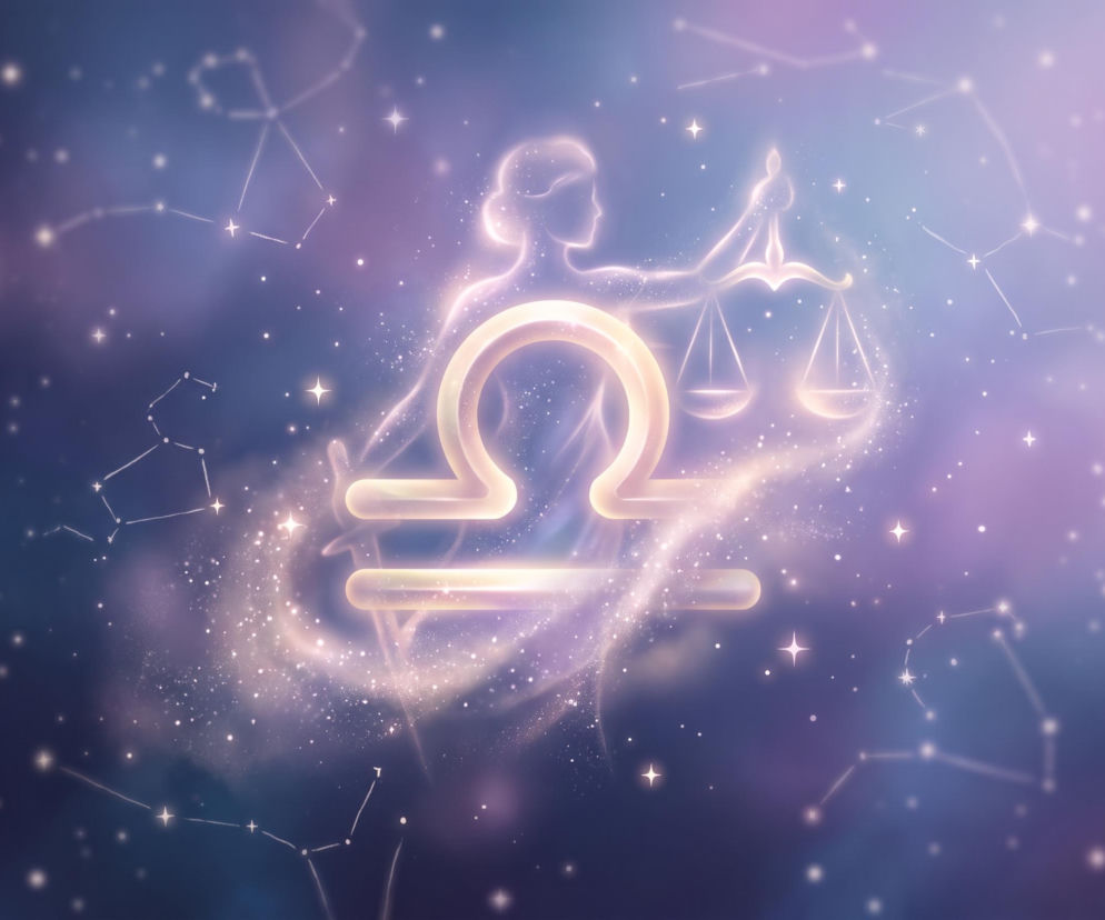 Świecący symbol Wagi na tle konstelacji gwiazd. O horoskopie dla Wagi i czasie wyciszenia przeczytasz na Eska.
