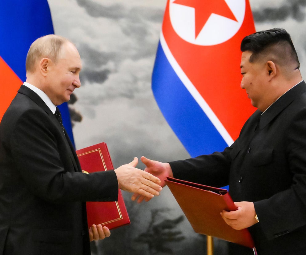 Władimir Putin i Kim Dzong Un podają sobie ręce na tle flag. O sojuszu Rosji i Korei Północnej pisze SE Portal Obronny.