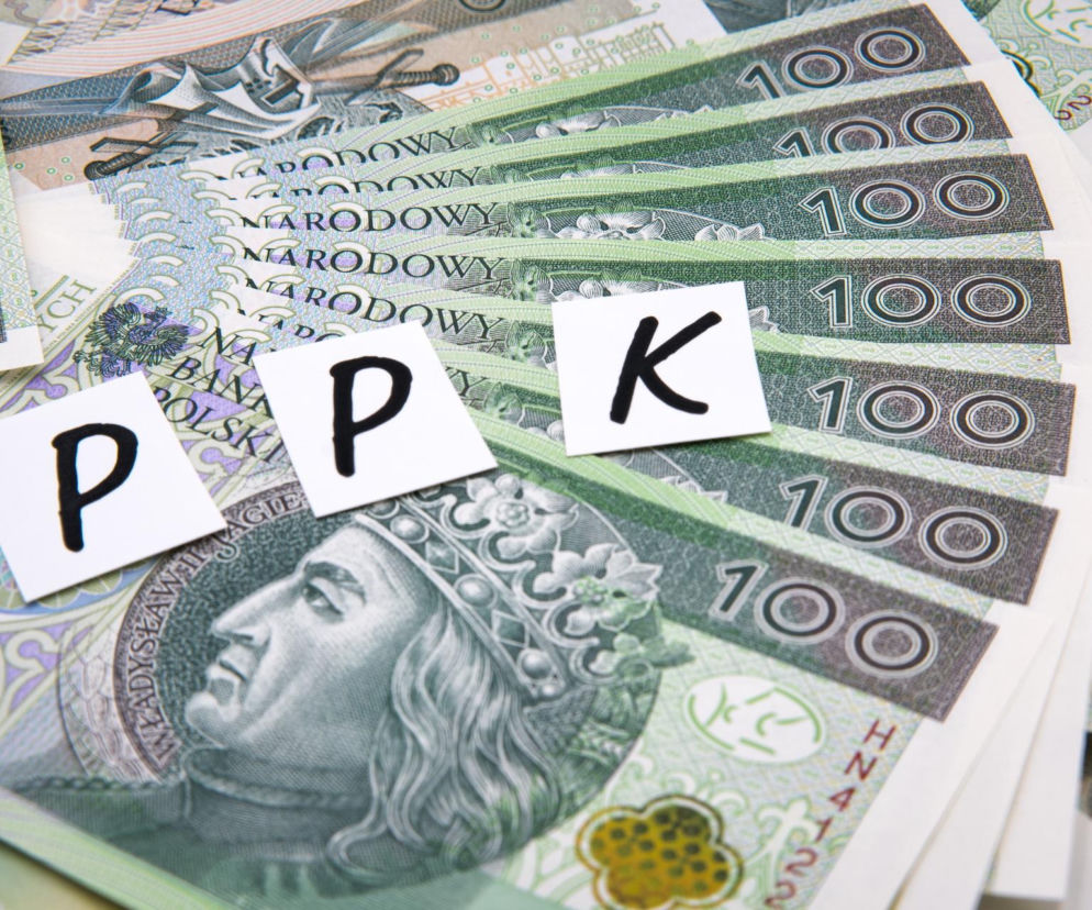 Białe kartki z napisem PPK na wachlarzu banknotów 100 złotych. O autozapisie do programu czytaj w SE Superbiz.