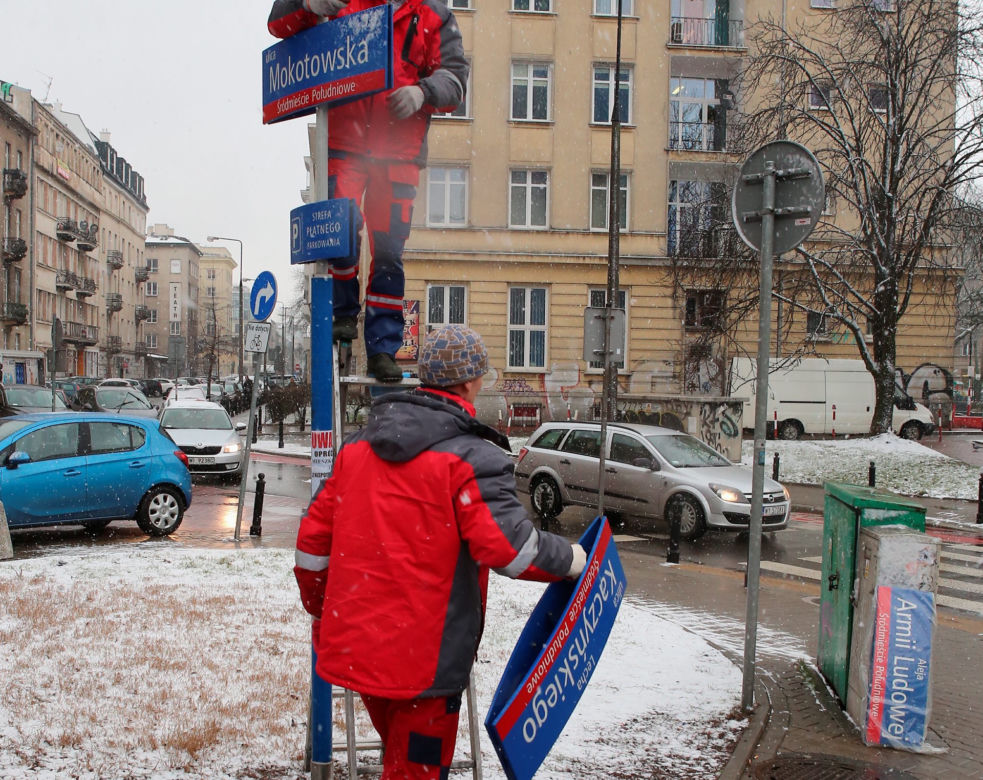 Dekomunizacja Warszawy. Zdejmowanie tablicy z Aleją Lecha Kaczyńskiego, zakładanie na powrót Armii Ludowej.