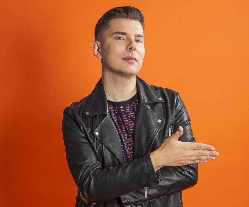 Michał Hanczak w ramonesce na pomarańczowym tle. O wywiadzie z duetem Plastic przeczytasz na Mediateka.