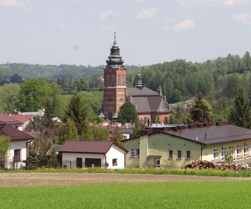 Panorama Ryglic z górującą wieżą kościoła i zielonymi wzgórzami. O urokach miasta przeczytasz na Eska Kraków.
