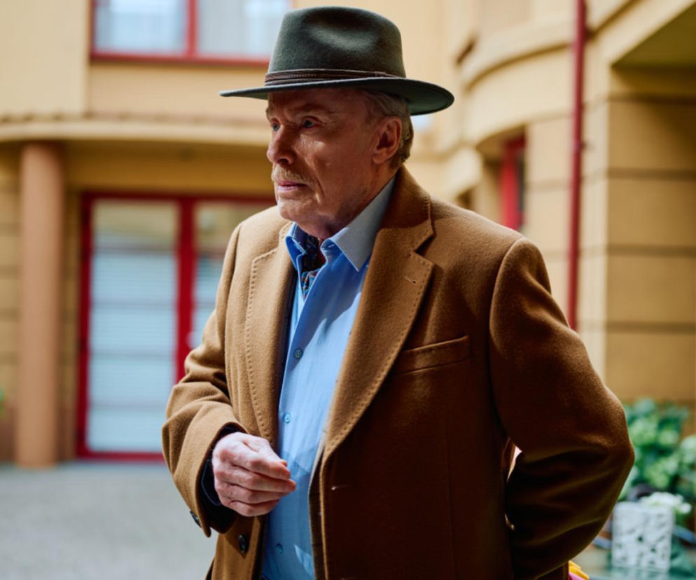 Juliusz z Na Wspólnej w brązowym płaszczu i kapeluszu. O jego miłosnych zawodach przeczytasz w serwisie Eska.