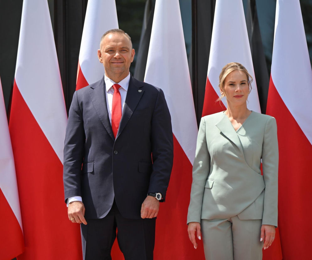 Para prezydencka Karol Nawrocki i Marta Nawrocka w eleganckich strojach, stojąca na tle powiewających flag Polski podczas gali AgroLiga 2025. O wsparciu dla polskiego rolnictwa możesz przeczytać na naszym portalu.