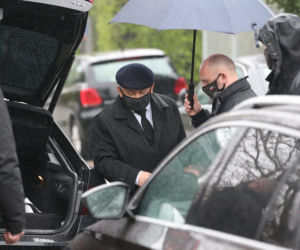 Pięciu ochroniarzy prowadzi Kaczyńskiego do bramy