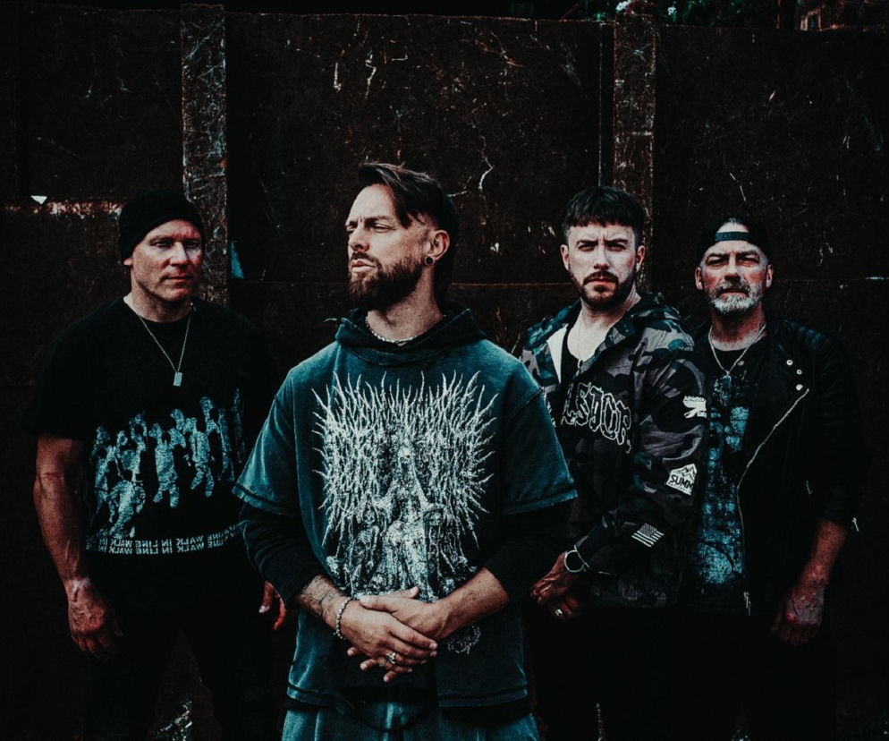 Członkowie Bullet For My Valentine na tle ciemnej ściany. O ich nowej płycie przeczytasz na EskaRock.