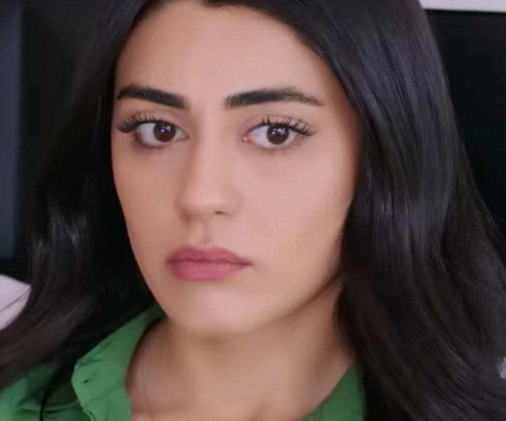 Zmartwiona Hancer, główna bohaterka serialu Panna młoda, ubrana w zieloną koszulę, z ciemnymi włosami i brązowymi oczami, spogląda w obiektyw, symbolizując niepokój związany z ciążą Beyzy. Więcej o losach postaci na Super Seriale.