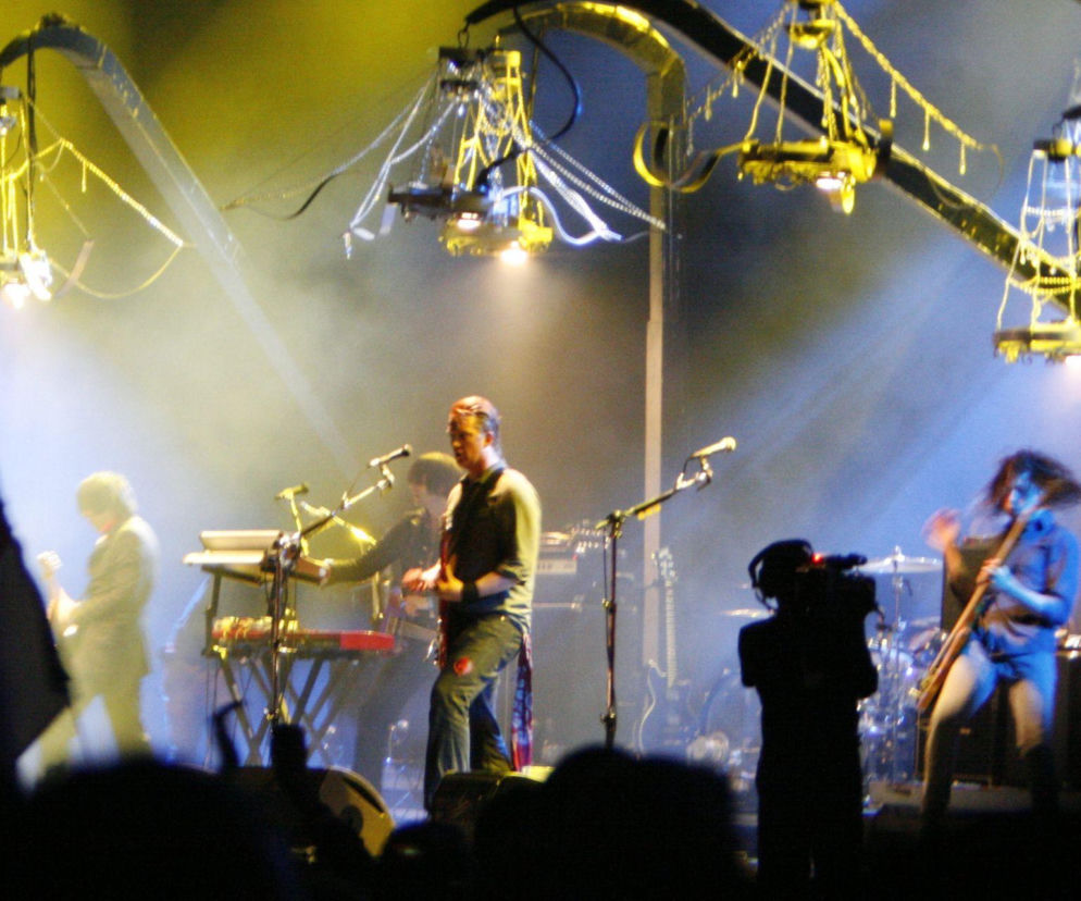 Zespół Queens of the Stone Age na scenie pod żyrandolami. O historii desert rocka przeczytasz na EskaRock.