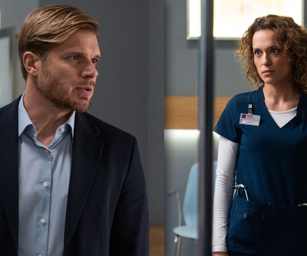 Maks Beger (Tomasz Ciachorowski) w granatowej marynarce i koszuli oraz Julka Burska (Aleksandra Hamakło) w stroju lekarskim, stojący w szpitalnym korytarzu. Julka zdeterminowana, by wziąć winę za błąd Igi na siebie, co można przeczytać na Super Seriale.