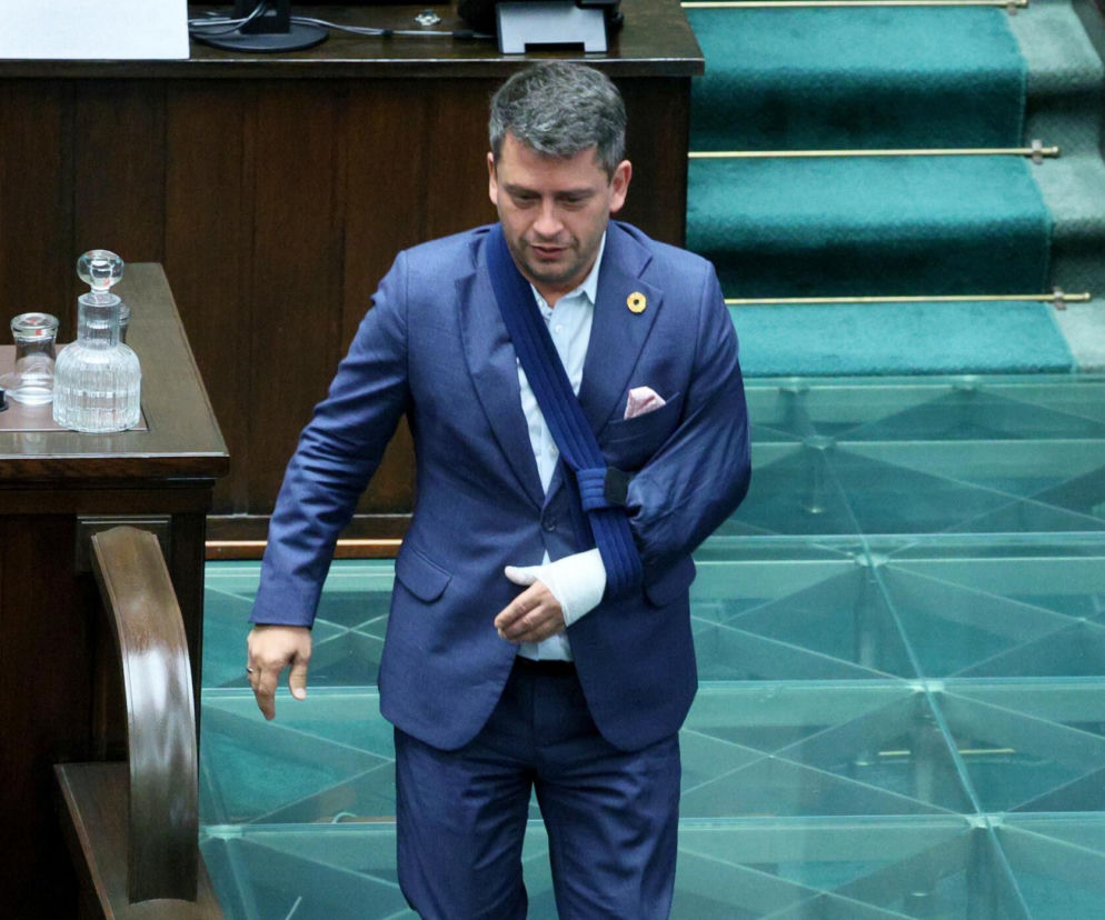 Poseł Paweł Śliz w garniturze z lewą ręką na temblaku w Sejmie. O jego wypadku na hulajnodze przeczytasz na SE Polityka.