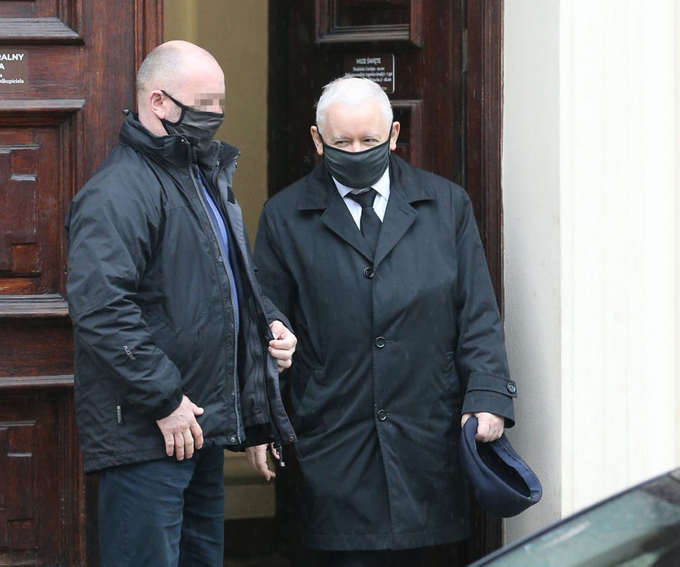 Pięciu ochroniarzy prowadzi Kaczyńskiego do bramy