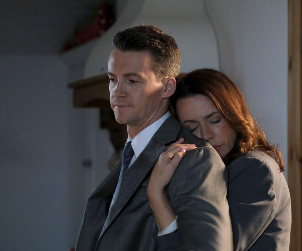 Kadr z serialu M jak miłość przedstawiający Martynę (Magdalena Turczeniewicz) obejmującą Jakuba (Krzysztof Kwiatkowski) od tyłu, głowę opiera na jego ramieniu, a on patrzy w dal, zamyślony. Ten romantyczny moment znajdziesz na Super Seriale.