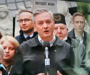 Robert Biedroń na tle religijnego hasła