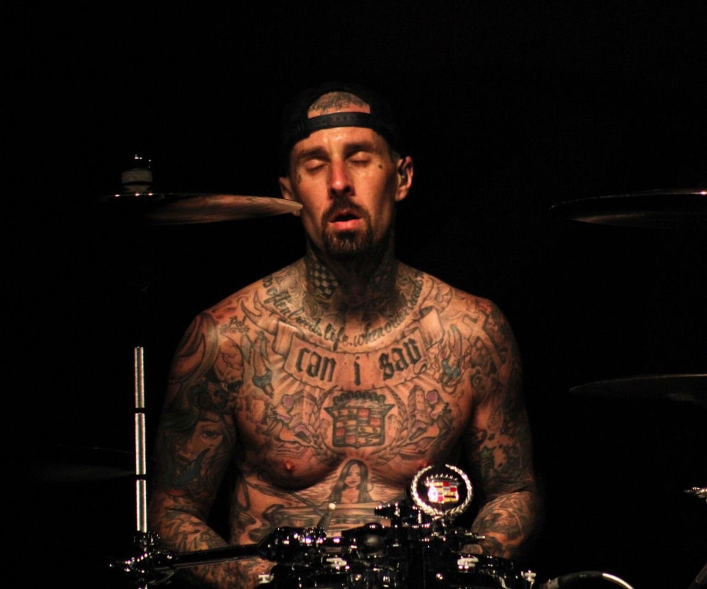 Wytatuowany Travis Barker gra na perkusji z zamkniętymi oczami. O operacji muzyka przeczytasz na EskaRock.