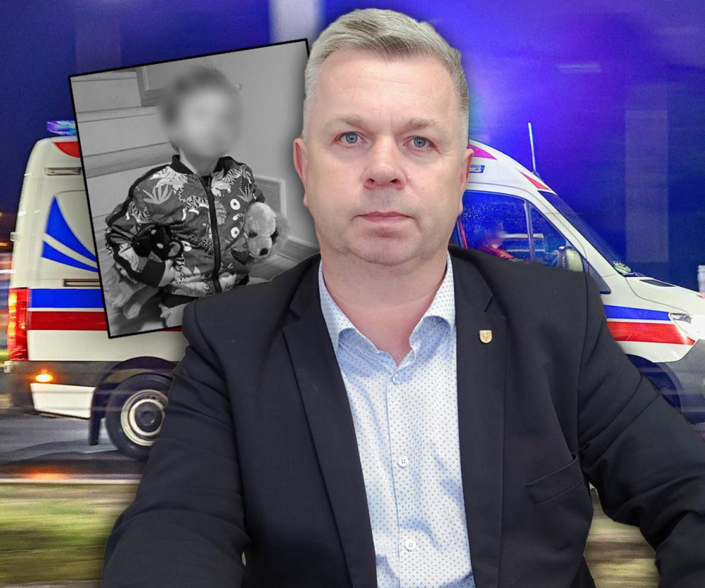 Burmistrz Wojciech Tomkiewicz na tle karetki. Obok miniatura dziecka. O tragedii w Jedliczu przeczytasz na SE.