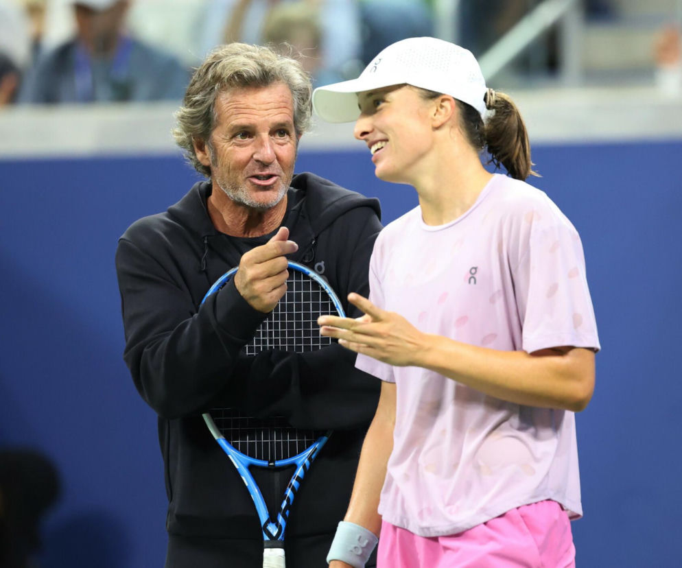 Uśmiechnięta Iga Świątek rozmawia z trenerem Tomaszem Wiktorowskim na korcie. O terminarzu US Open przeczytasz na SE Supersport.