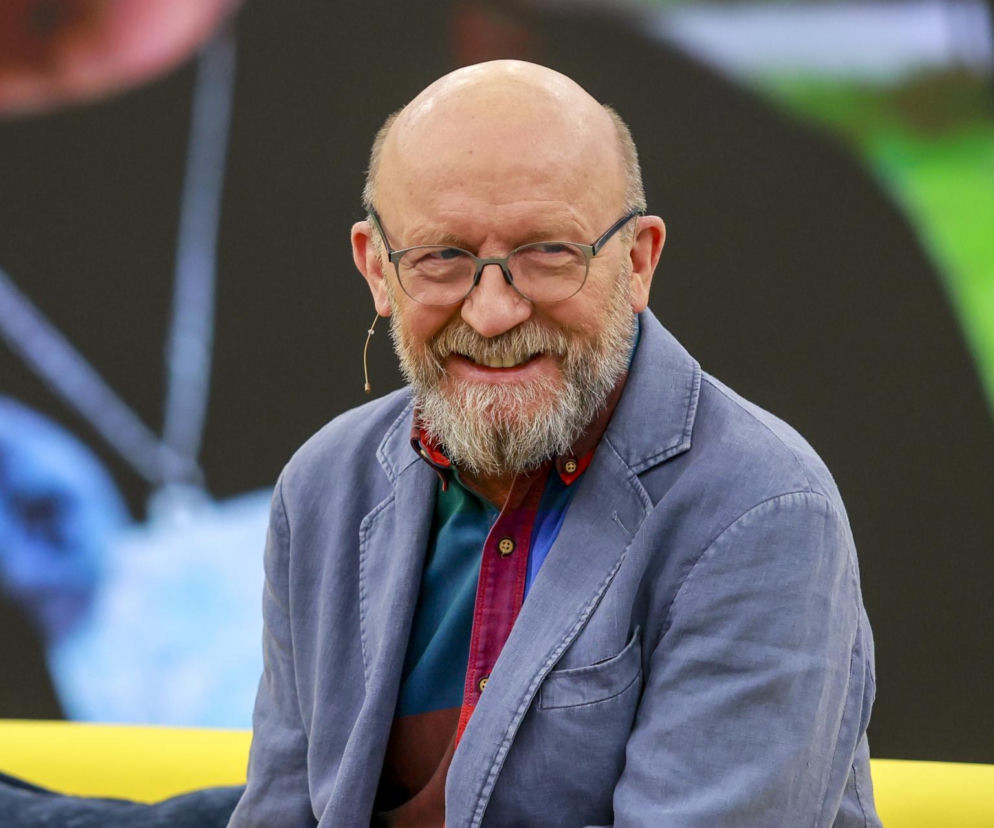 Uśmiechnięty aktor Artur Barciś w niebieskiej marynarce i okularach. O przemianie gwiazdy SE informuje w galerii.