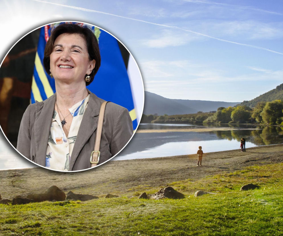 Uśmiechnięta włoska minister ds. rodziny Eugenia Roccella na tle flag, obok jeziora Vico, gdzie zaginął jej mąż. Scena oddaje tragiczną historię, o której można przeczytać na naszym portalu.