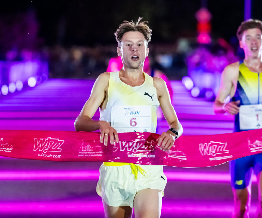 Marcin Biskup przerywa taśmę na mecie biegu Praska 5K Run w Warszawie. O rekordach nocnego biegania przeczytasz na SE.