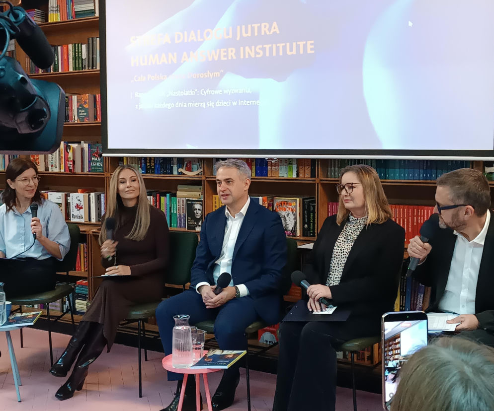 Panel dyskusyjny z udziałem Krzysztofa Gawkowskiego i Małgorzaty Rozenek-Majdan na temat zagrożeń online dla dzieci, w kontekście akcji „Cała Polska czyta Dorosłym”. W tle regały z książkami i ekran z prezentacją. Więcej o akcji na Super Biznes.