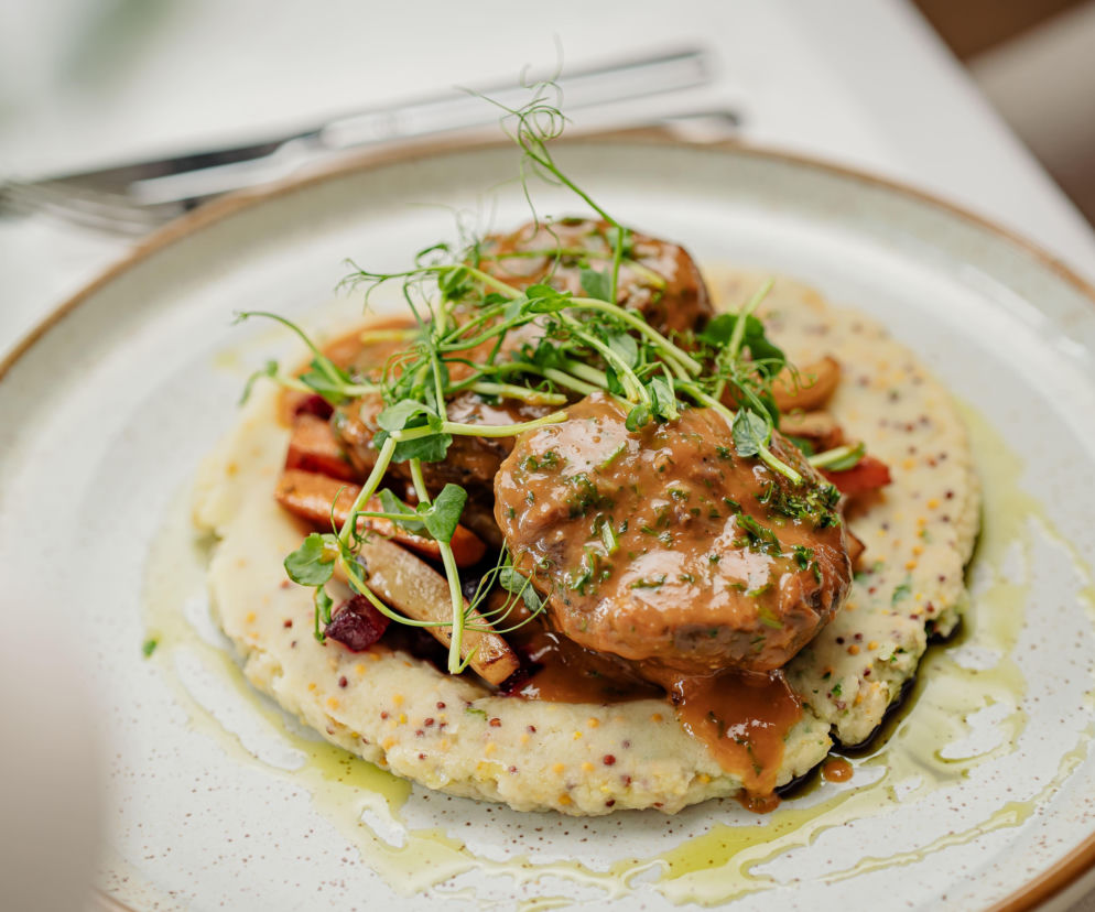 Danie z duszonymi policzkami wołowymi na puree, ozdobione ziołami. O RestaurantWeek przeczytasz na SE.