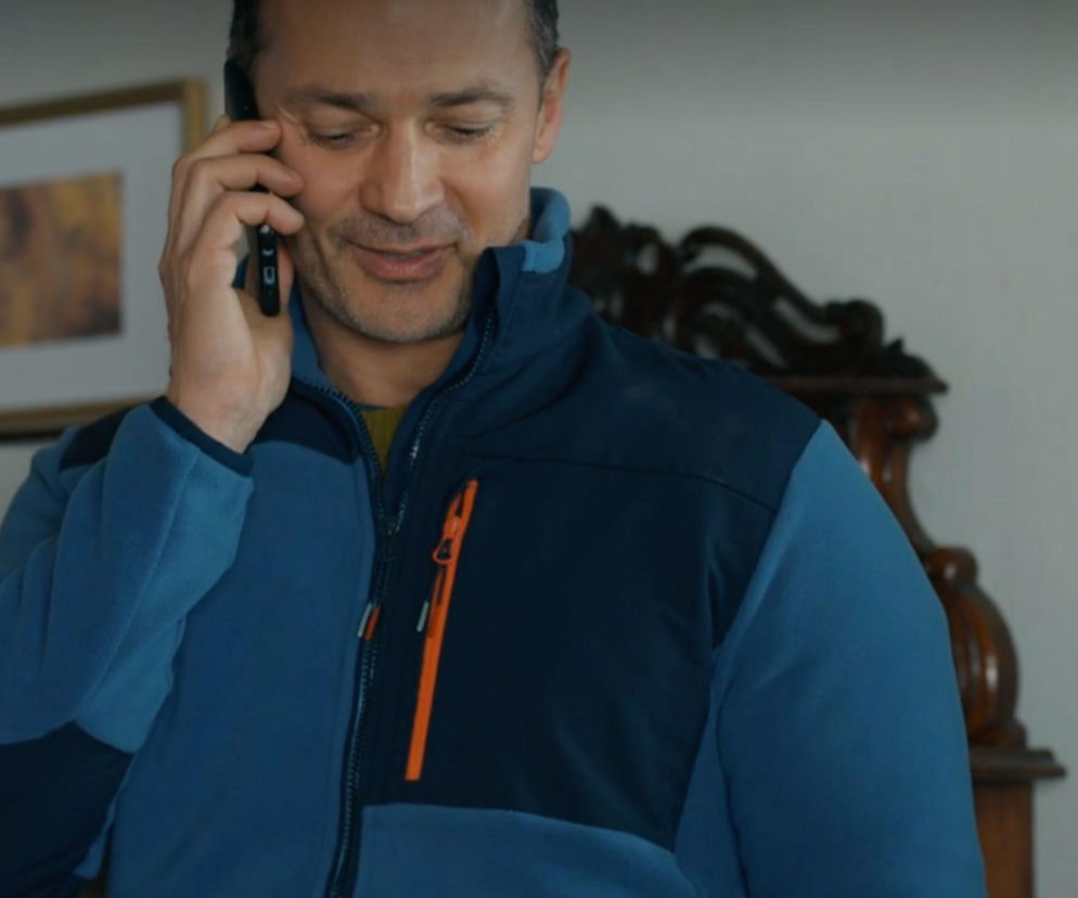 Mariusz uśmiecha się podczas rozmowy przez telefon. O losach bohaterów serialu przeczytasz na SE Superseriale.