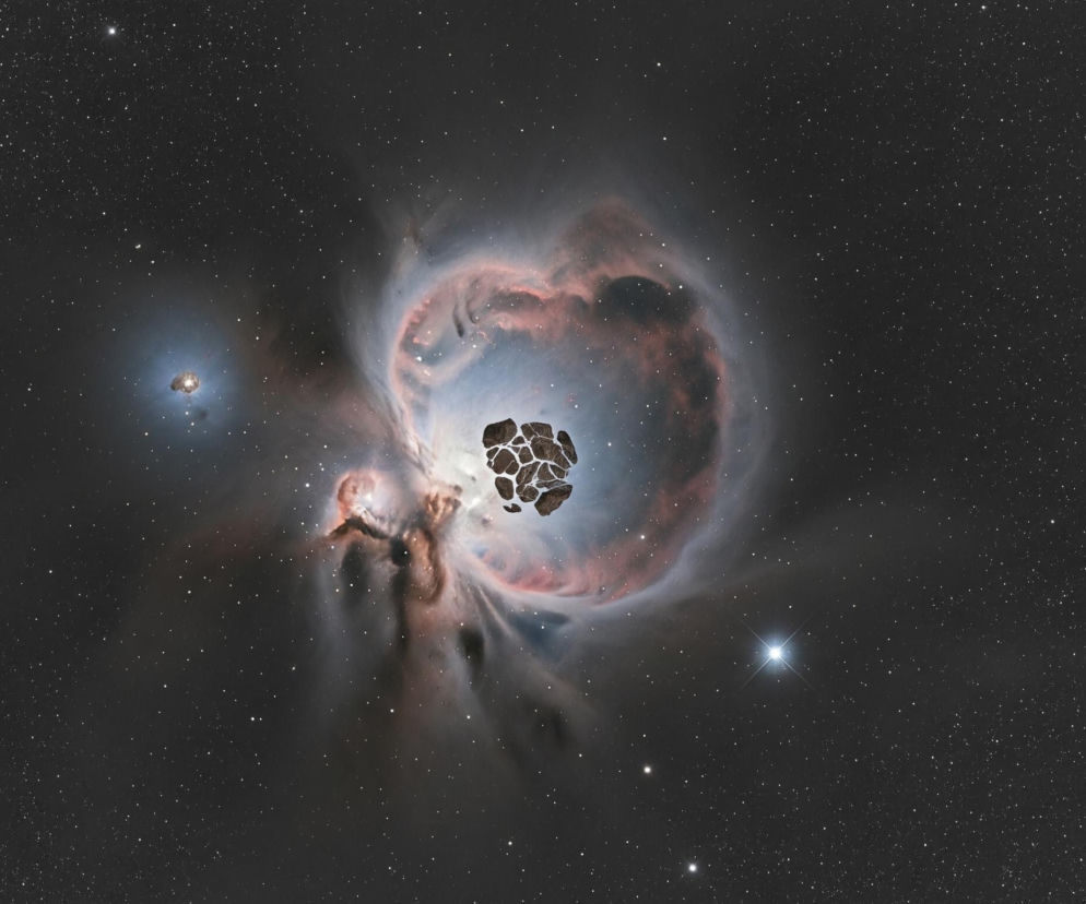 Pośrodku obrazu znajduje się rozległa mgławica o nieregularnym, owalnym kształcie, otaczająca ciemne, spękane ciało niebieskie. Mgławica ukazuje różnorodność barw, głównie w odcieniach błękitu, różu i pomarańczu, z wyraźnymi smugami i strukturami chmur. Centralne, ciemne ciało niebieskie, przypominające zbiór połączonych nieregularnych kawałków, ma odcienie szarości i brązu z jasnymi obramowaniami. Całość otacza ciemne tło kosmosu, usiane niezliczonymi, drobnymi, białymi punktami gwiazd. W lewej części mgławicy widoczna jest mniejsza, jasna niebiesko-pomarańczowa struktura, a w prawej dolnej części obrazu jasno świecąca gwiazda z promieniami.