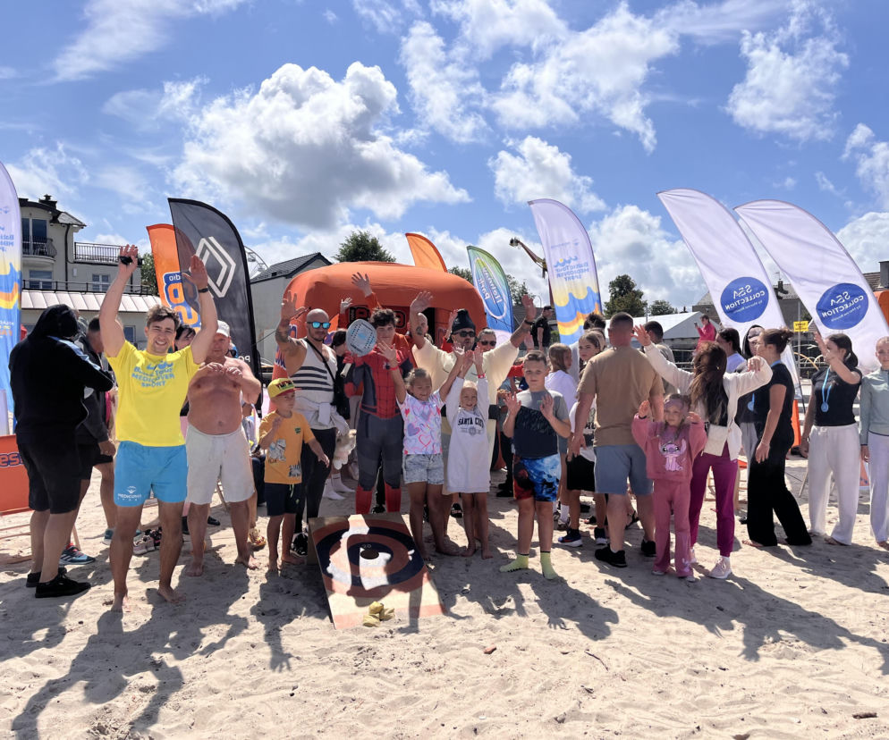 Grupa uśmiechniętych osób na plaży w Darłowie podczas Baltic Tour. O wydarzeniu przeczytasz w Eska Szczecin.