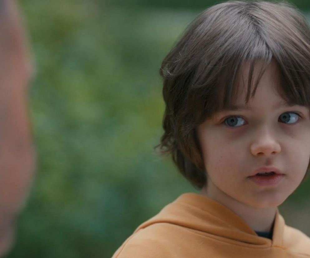 Mateusz (Filip Kowalewicz) z serialu „Barwy szczęścia” z zaniepokojoną miną patrzy na Sebastiana (Marek Krupski), z którym ma zamieszkać. Chłopiec nie chce opuszczać domu, czekając na mamę. Więcej o losach Mateusza przeczytasz na stronie Super Seriale.