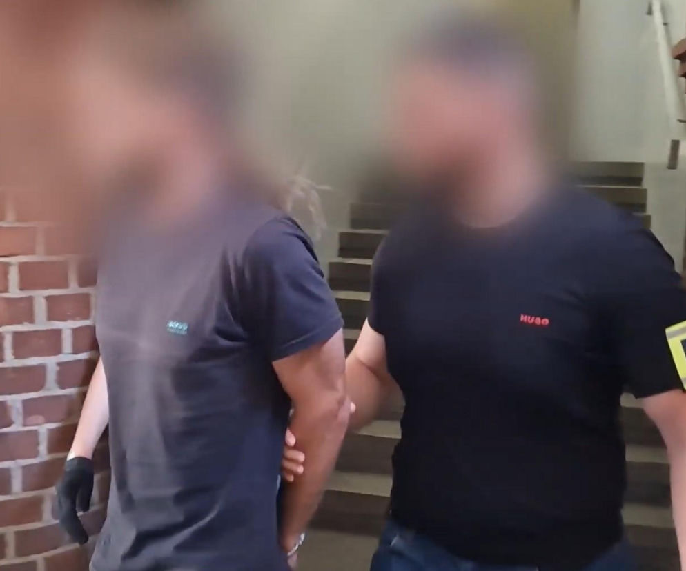 Policjant prowadzi zatrzymanego napastnika z Wrocławia. O ataku na sprzedawcę przeczytasz na SE Wrocław.