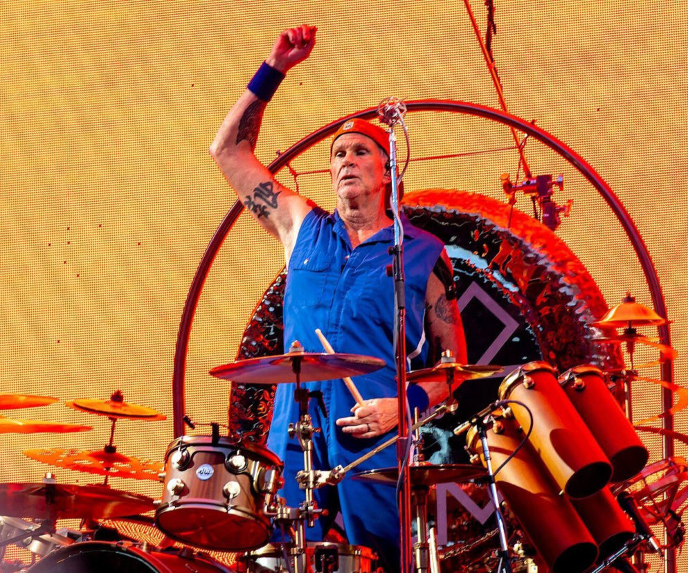 Perkusista Chad Smith z Red Hot Chili Peppers za bębnami z uniesioną pięścią. O planach zespołu przeczytasz na EskaRock.