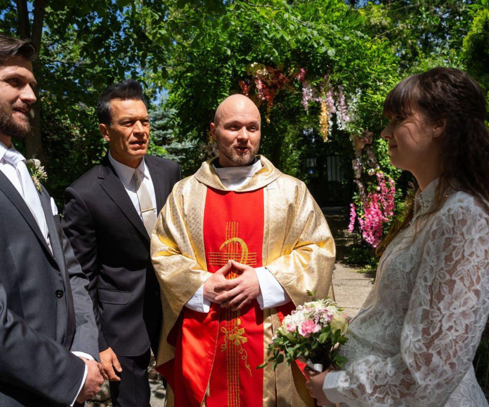 Darek, Falkowicz, ksiądz i Matylda w sukni ślubnej podczas ceremonii. O jubileuszu Na dobre i na złe przeczytasz w Eska.