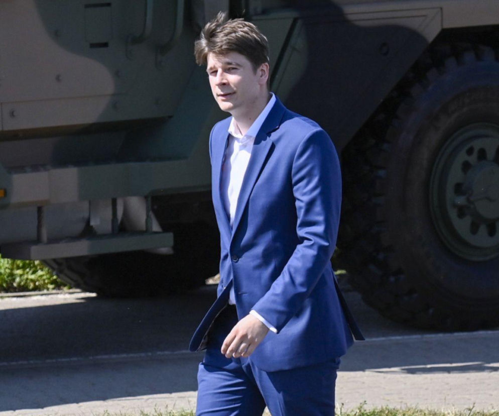 Daniel Nawrocki w niebieskim garniturze na tle wojskowego pojazdu. O jego karierze i rodzinie przeczytasz na Eska.