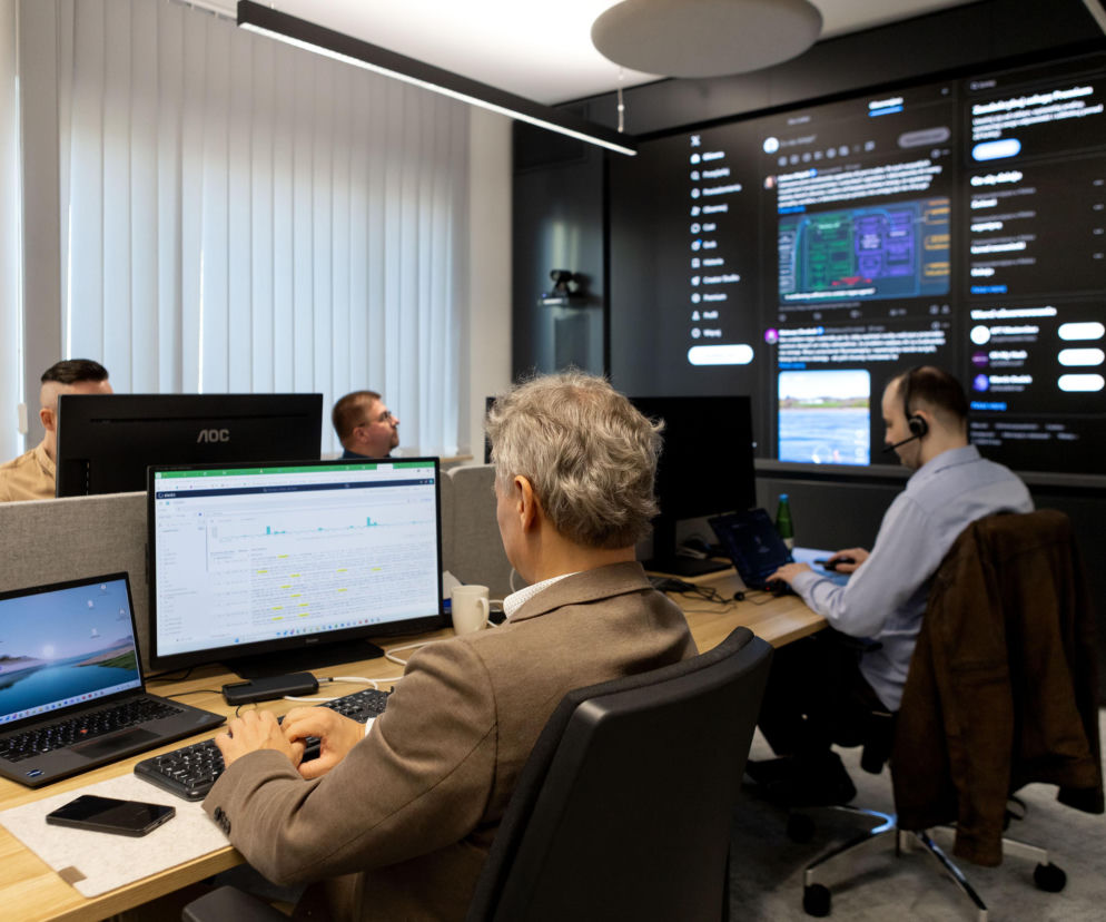 Specjaliści IT w biurze monitorują dane na ekranach. O walce z cyberatakami w ochronie zdrowia przeczytasz na Poradnik Zdrowie.