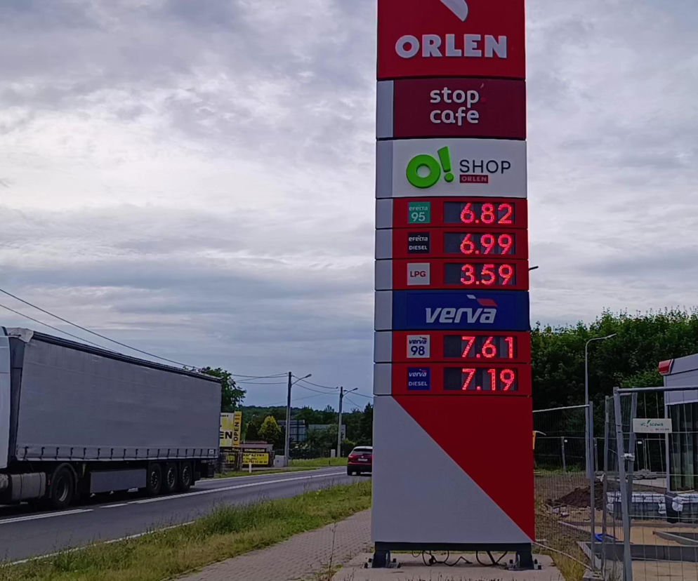 Pylon stacji Orlen z cenami paliw. Obok przejeżdża ciężarówka. O nowych stawkach benzyny i diesla czytaj w SE Superbiz.